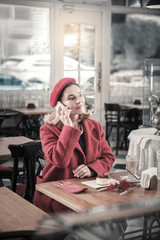 Concentrated female person talking per telephone with partner