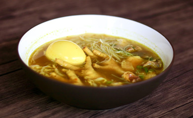 Soto ceker or chicken feet soup on wood background. 