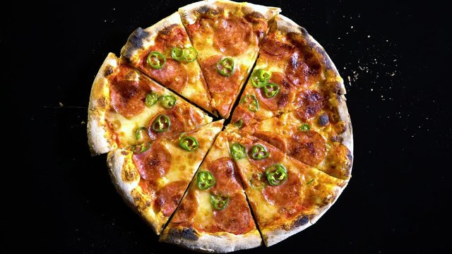 Top view of slices of baked pizza, Empty the plate - stop motion animation. Slices of pizza that disappear from the frame. Time lapse Fresh Salami Pizza with peppers. Empty the table. 