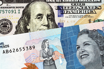 A macro image of a blue, two thousand Colombian peso bank note with a blue, crisp American one...