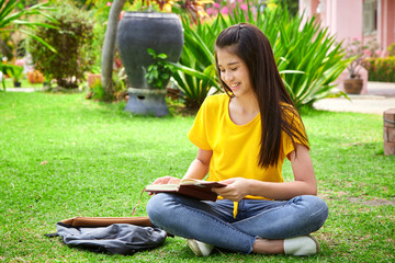 student girl reading a book in park