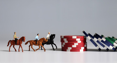 Miniature of horse rider on pile of casino chip. The concept of horse racing betting.
