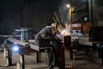 Welding with sparks by Process fluxed cored arc welding ,Industrial steel welder part in factory welder Industrial automotive part in factory.