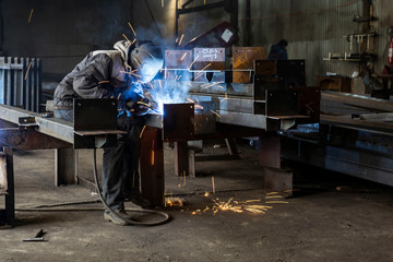 Welding with sparks by Process fluxed cored arc welding ,Industrial steel welder part in factory...