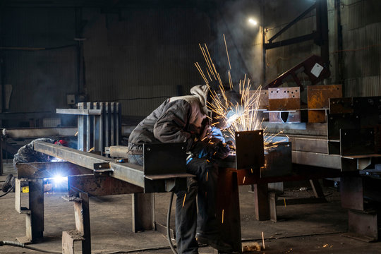 Welding with sparks by Process fluxed cored arc welding ,Industrial steel welder part in factory welder Industrial automotive part in factory.