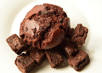 Delicious Double Chocolate Muffin with Chocolate Brownies closeup on a white plate.