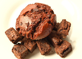 Delicious Double Chocolate Muffin with Chocolate Brownies closeup on a white plate.