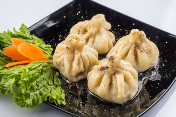 Georgian dumplings Khinkali with meat and red papper, on brown plate
