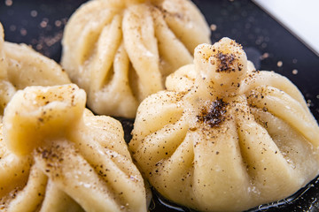 Georgian dumplings Khinkali with meat and red papper, on brown plate