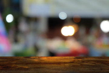 Empty dark wooden table in front of abstract blurred bokeh background of restaurant . can be used for display or montage your products.Mock up for space.