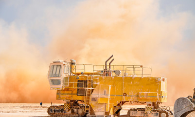 Rock dust clouds and Concrete pavement machine on the site during detonator blast 