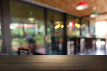 Empty dark wooden table in front of abstract blurred bokeh background of restaurant . can be used for display or montage your products.Mock up for space.