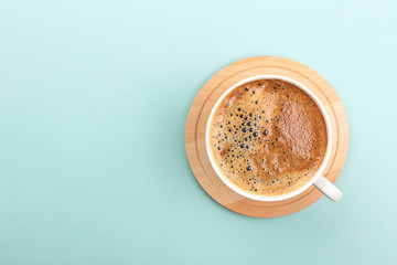 Cup of coffee on light green background. Minimal composition. Flat lay, top view. Copy space.