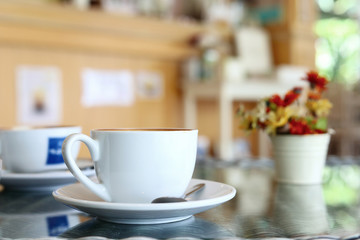 white cup of hot coffee drink put on table in cafe restaurant