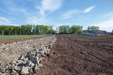Agricultural field, which is fenced and between there is a field road