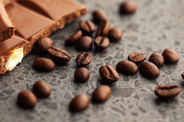 Coffee beans and dark chocolate glaze on gray background