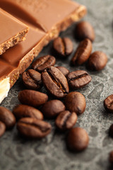 Coffee beans and dark chocolate glaze on gray background