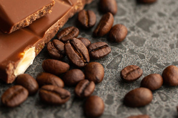 Coffee beans and dark chocolate glaze on gray background