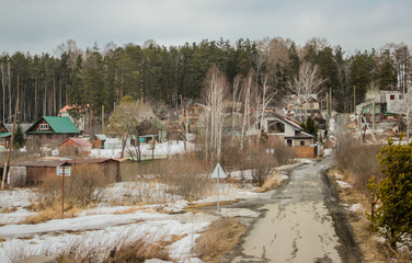 Spring, in some places there is snow, the railway bridge over the river, the village. 