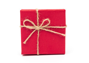 Red gift box tied with a rope tied into a bow isolated on a white background