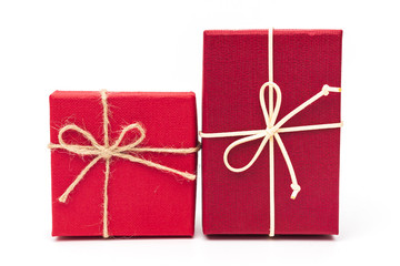 Red gift box tied with a rope tied into a bow isolated on a white background