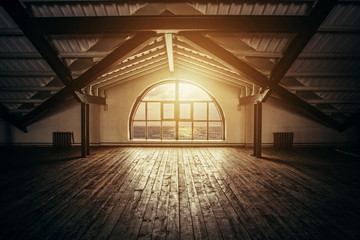Loft Interior design. Sea sunset and sun rays from big arch window, wooden floor