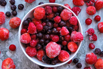 Frozen berries.Top view. Frozen delicious berries on blue background, closeup. Assorted frozen berries background. Raspberries, black currant and strawberries on blue background, copy space.
