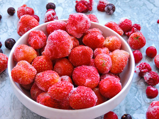 Frozen berries.Top view. Frozen delicious berries on blue background, closeup. Assorted frozen berries background. Raspberries, black currant and strawberries on blue background, copy space.