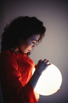 Young woman mixed race keep glowing ball lamp