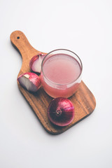 Medicinal Onion juice/syrup in a glass with raw onions. selective focus