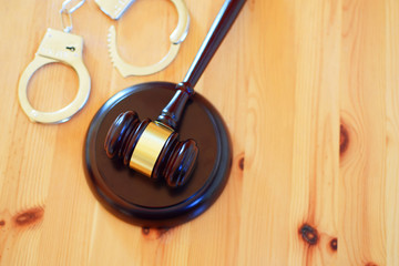 Judges gavel or law mallet and handcuffs on wooden background. Judgement, legal system and time for...