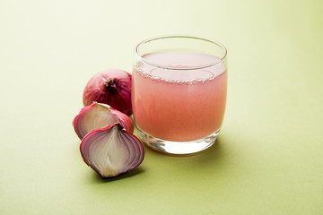Medicinal Onion juice/syrup in a glass with raw onions. selective focus