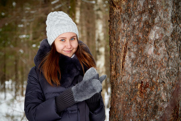 Portrait of a girl in a pine forest on a winter day
