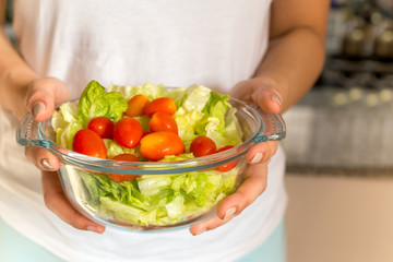 Lifestyles and health food concept hands holding organic salad blow in kitchen.