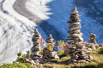 Glacier in the alps with buddhistic flags and stone tower