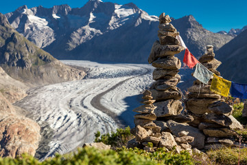 Glacier in the alps with buddhistic flags and stone tower