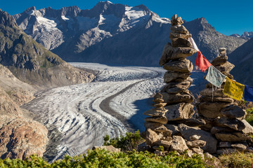 Glacier in the alps with buddhistic flags and stone tower