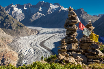 Glacier in the alps with buddhistic flags and stone tower