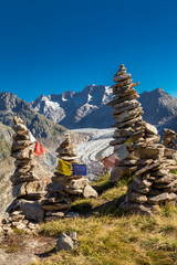 Glacier in the alps with buddhistic flags and stone tower