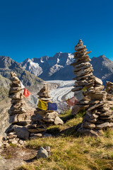 Glacier in the alps with buddhistic flags and stone tower