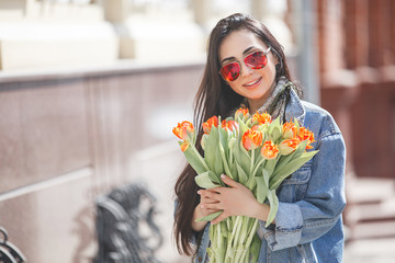 Woman with spring bouquet. Lady holding tulips. Attractive female with flowers.