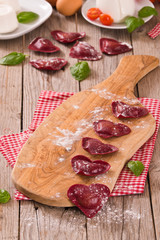 Red heart ravioli with tomato, mozzarella and basil.