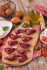 Red heart ravioli with tomato, mozzarella and basil.