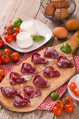 Red heart ravioli with tomato, mozzarella and basil.