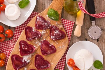 Red heart ravioli with tomato, mozzarella and basil.