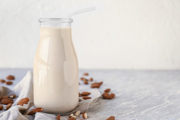 Bottle of healthy almond milk on table