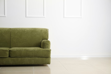 Comfortable sofa near white wall