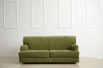 Comfortable sofa near white wall