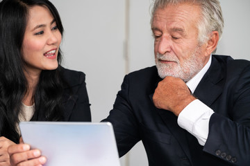 Senior executive manager and young businesswoman working in meeting room in the office. The woman...