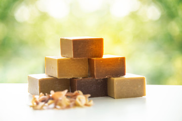 Natural handmade soap bars, spa organic soap gold color or golden brown made by natural with green natural background blur.